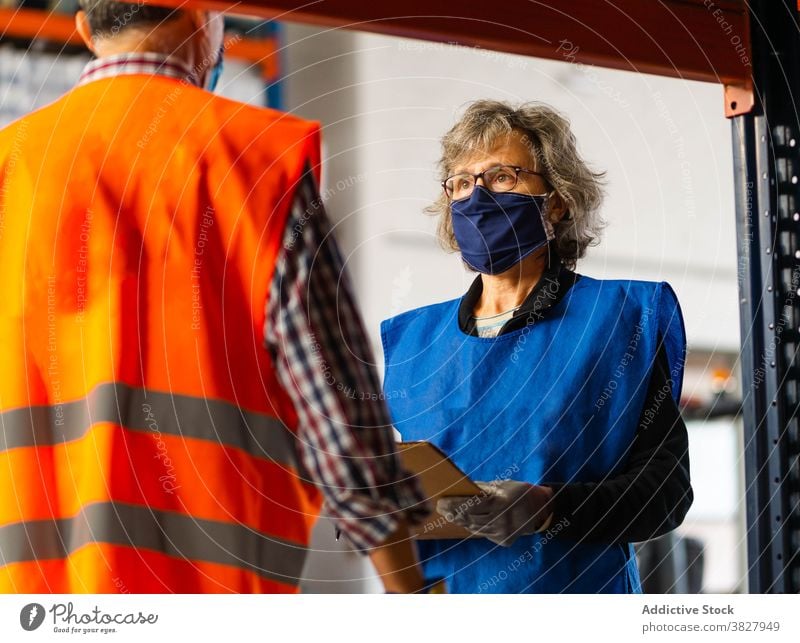 Professionelle Lagerarbeiter bei der Besprechung von Arbeitsdetails Arbeiter Kollege Vorgesetzter Lagerhalle diskutieren reden ernst Arbeitsplatz bei der Arbeit