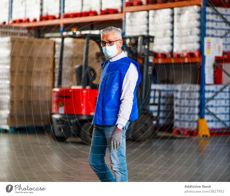 Ruhiger männlicher Arbeiter im Lagerhaus stehend Mann professionell Lagerhalle bei der Arbeit Industrie Uniform Windstille Fokus Speicher industriell