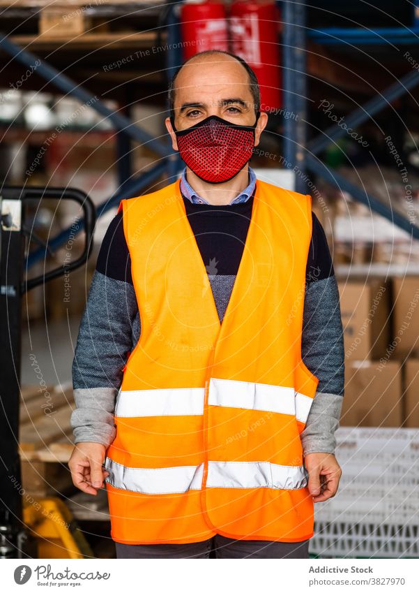 Männliche Lagerarbeiter in Uniform stehen in der Nähe von Regal im Lager Mann Arbeiter Lagerhalle professionell bei der Arbeit Speicher Beruf Arbeitsplatz