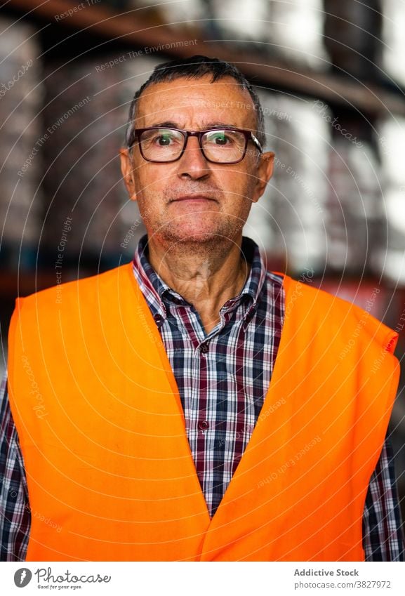 Männliche Lagerarbeiter in Uniform stehen in der Nähe von Regal im Lager Mann Arbeiter Lagerhalle professionell bei der Arbeit Speicher Beruf Arbeitsplatz