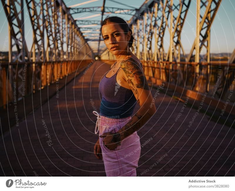 Stilvolle Frau in Tattoos stehen in der Stadt trendy Brücke Metall Sonnenuntergang Sommer sich[Akk] entspannen ruhen genießen jung urban Freiheit Freude froh