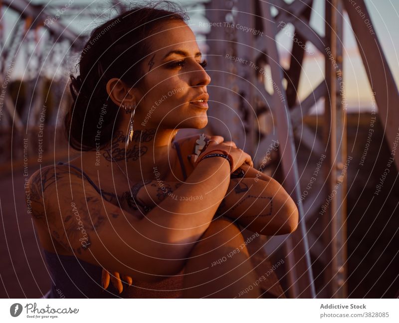 Stilvolle Frau in Tattoos stehen in der Stadt trendy Brücke Metall Sonnenuntergang Sommer sich[Akk] entspannen ruhen genießen jung urban Freiheit Freude froh