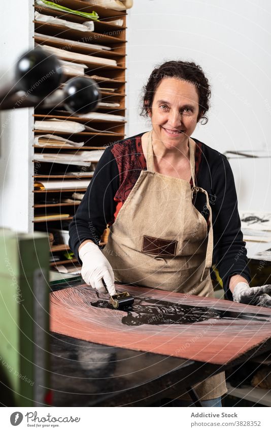 Handwerkerin bei der Herstellung eines Drucks in der Gravurwerkstatt gravieren Druckgrafik Tusche drucken kreieren Kunstgewerbler professionell Kunstwerk