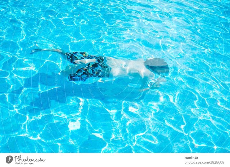 Junger Mann genießt den Tag im Schwimmbad Pool Schwimmsport spielerisch Sommer Wasser attraktiv cool frisch Feiertage Spaß lustig Sport sportlich Badehose