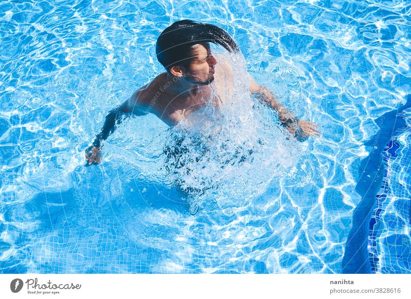 Junger Mann genießt den Tag im Schwimmbad Pool Schwimmsport spielerisch Sommer Wasser attraktiv cool frisch Feiertage Spaß lustig Sport sportlich Badehose