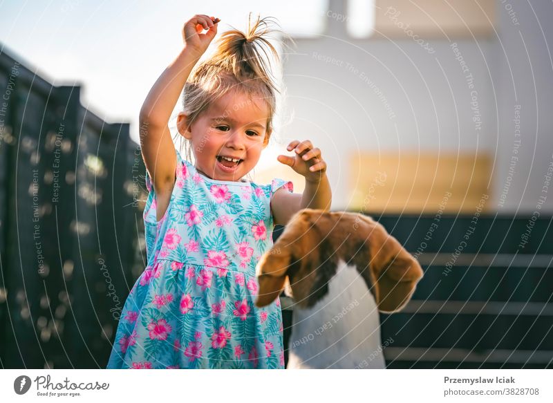 Kleines Mädchen rennt mit einem Beagle-Hund im Garten an einem Sommertag. Konzept Haustier mit Kindern. Baby Zusammengehörigkeitsgefühl 2-3 Familie Leckerbissen