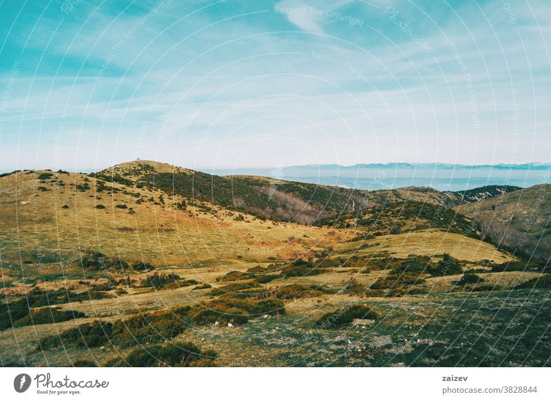 Blick auf eine Landschaft mit einigen gelblichen Hügeln Berge wild Umwelt Natur Vegetation Sträucher grün Gelblich braun Himmel Boden Hintergrund Bäume