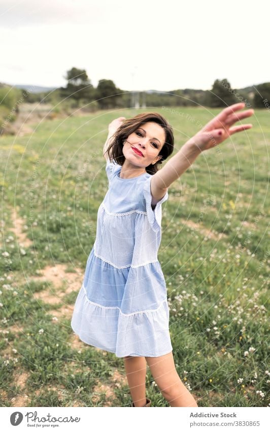 Glückliche Frau zu Fuß im Feld im Sommer schlendern Wiese Spaziergang Sommerzeit Verlockung romantisch Freiheit Arme auseinander Gras Wald Natur tagsüber Tal