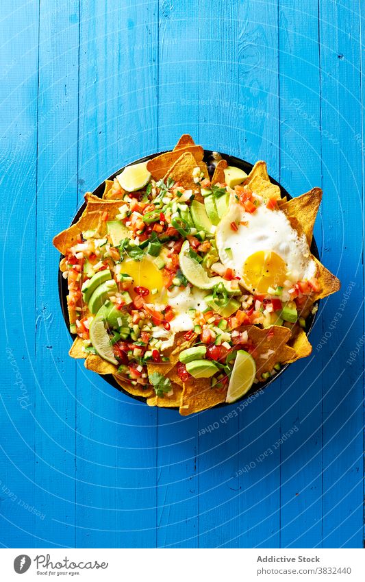 Gericht Chilaquiles mit Avocado Lebensmittel Speise mexikanisch Tortilla Draufsicht Frühstück Overhead schwarze Bohnen nachos Koriander Saucen gebraten Mahlzeit