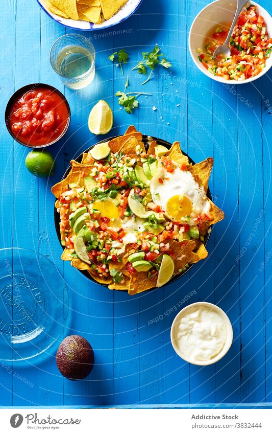 Gericht Chilaquiles mit Avocado Lebensmittel Speise mexikanisch Tortilla Draufsicht Frühstück Overhead schwarze Bohnen nachos Koriander Saucen gebraten Mahlzeit