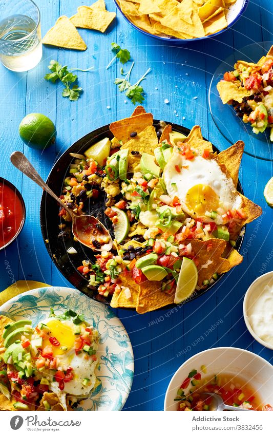 Gericht Chilaquiles mit Avocado Lebensmittel Speise mexikanisch Tortilla Draufsicht Frühstück Overhead schwarze Bohnen nachos Koriander Saucen gebraten Mahlzeit