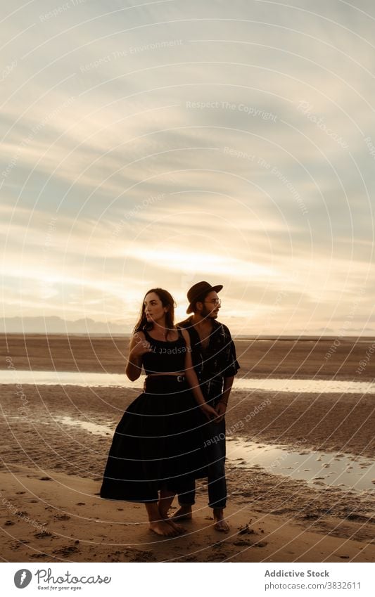 Paar stehend auf nassem Sand bei Sonnenuntergang Strand Händchenhalten Liebe Termin & Datum romantisch amourös sanft Valentinsgruß Mann Frau Freundin Stil