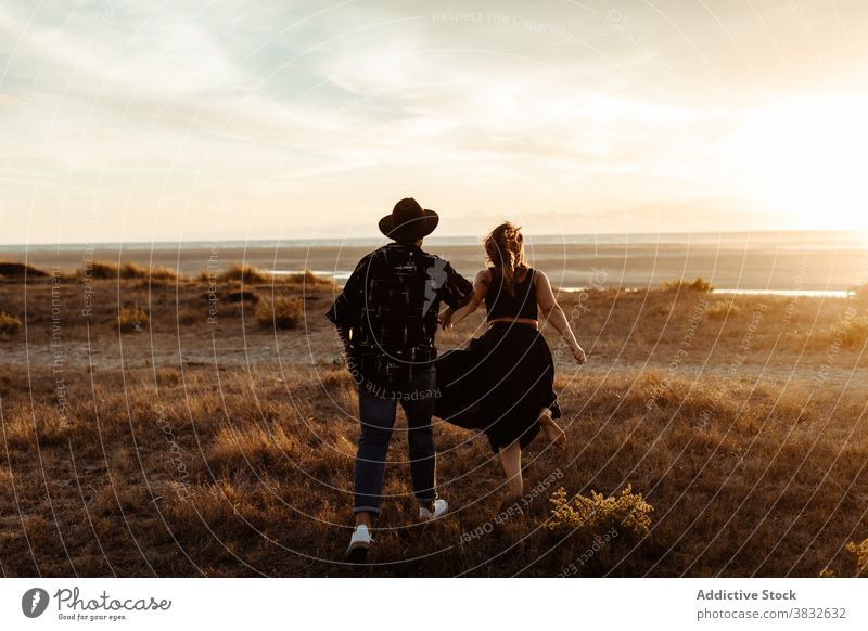 Paar läuft durch Feld am Abend Termin & Datum laufen Wiese Morgendämmerung Liebe Natur Partnerschaft Freiheit Zusammensein Mann Frau Freund Freundin Sommerzeit