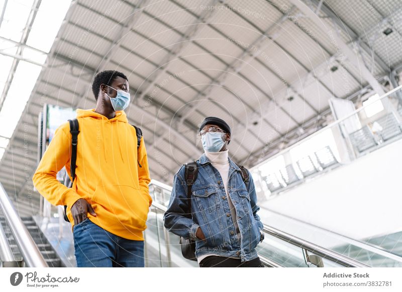 Schwarze Männer auf Rolltreppe im Bahnhof Zug Station Reisender Mundschutz Coronavirus Treppenhaus sich[Akk] bewegen behüten ethnisch schwarz Afroamerikaner