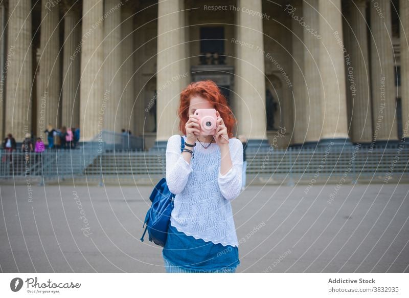 Weiblicher Tourist fotografiert mit Sofortbildkamera in der Nähe der alten Kathedrale Frau Reisender fotografieren sofort Fotoapparat berühmt schießen