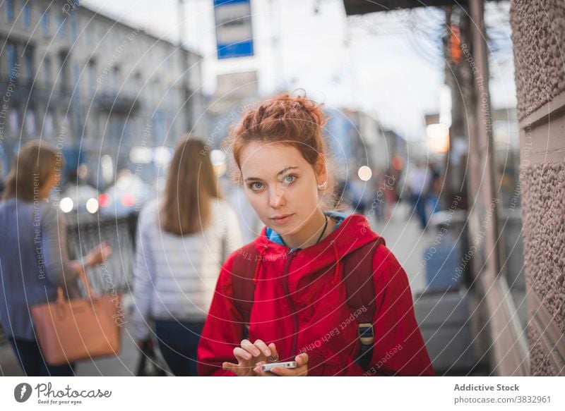 Junge rothaarige Frau stehend in der Stadt Rotschopf rote Haare urban Großstadt jung Wind ernst tausendjährig Straße krause Haare lange Haare Saint Petersburg