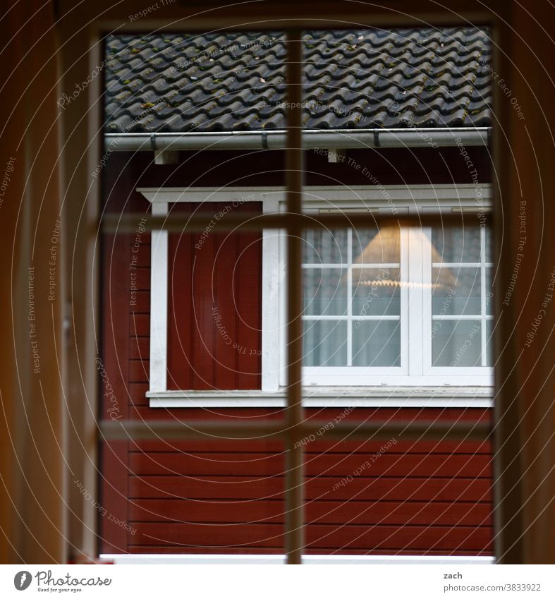 Hinter den Fenstern Haus Hütte Holzhaus Holzhütte Fischerhütte zweiundfünfzig Brett Fensterscheibe Reflexion & Spiegelung Fassade rot Lampe leuchten