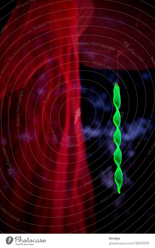 leuchtend neongrüne Spirale vor unscharfem Hintergrund, rote Tücher zieren die Szene neonfarbig Schwache Tiefenschärfe Ambiente Dekoration & Verzierung hängend