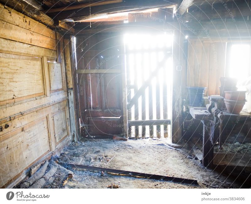 Alter Schuppen im Gegenlicht Farbfoto Außenaufnahme Tag Sonnenlicht Menschenleer verfallen Vergänglichkeit Schmutzig Holztür Holzwand Holzschuppen Innenraum