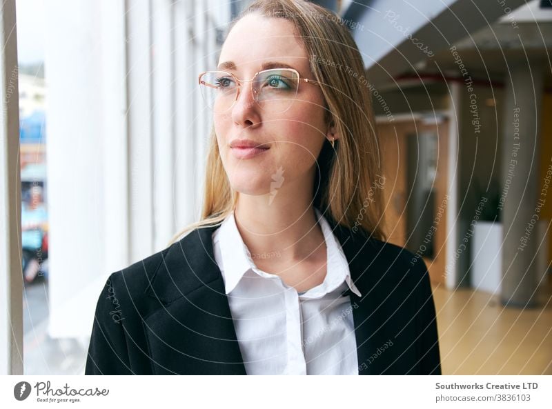 Porträt einer jungen Geschäftsfrau mit Brille, die während einer Gesundheitspandemie in einem modernen Büro steht Business arbeiten positiv selbstbewusst