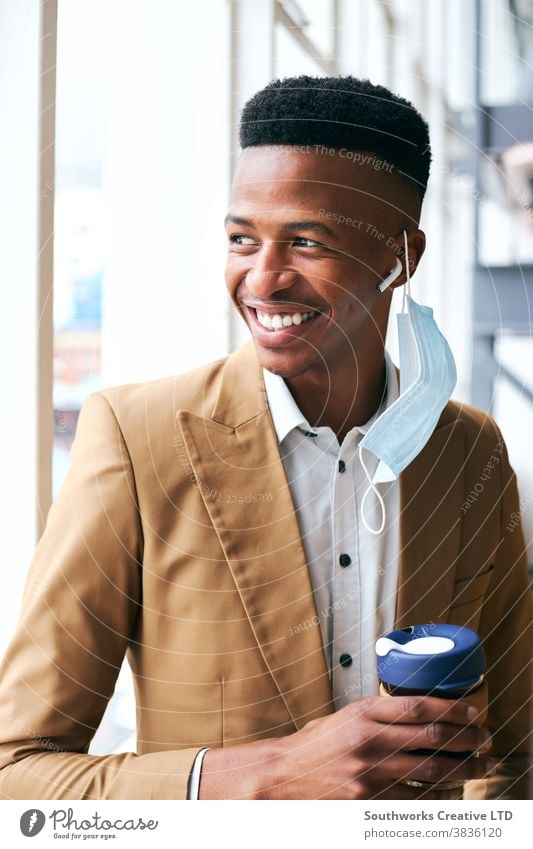 Porträt eines jungen Geschäftsmannes mit Maske, der während einer Pandemie in einem modernen Büro steht und Kaffee hält Business Gesichtsmaske Gesichtsbedeckung