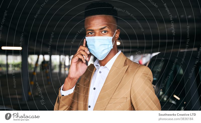 Geschäftsmann trägt während einer Gesundheitspandemie Maske mit Mobiltelefon auf dem Flughafen-Parkplatz Business Gesichtsmaske Gesichtsbedeckung tragend ppe