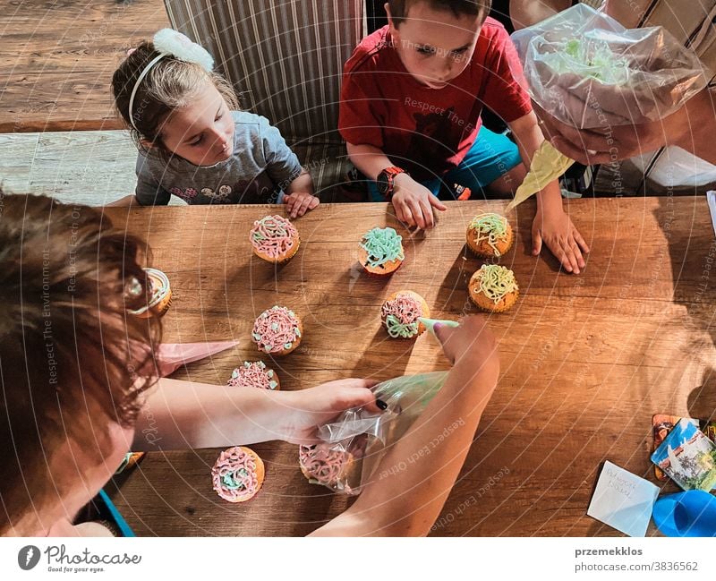 Kinder backen Muffins, bereiten Zutaten vor, dekorieren Kekse Cupcake dekorierend vorbereitend Essen zubereiten Familie heimisch Zusammensein Kindheit Glück