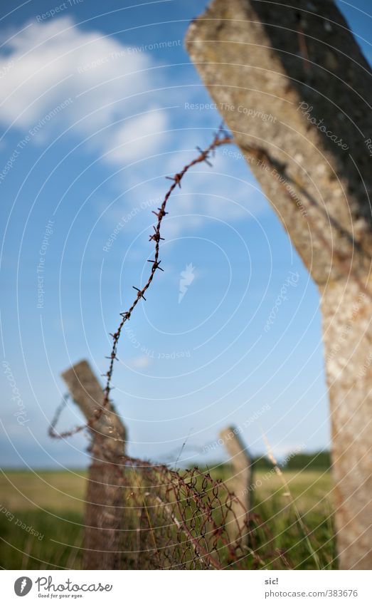 Stacheldraht Landschaft Himmel Wolken Sommer Beton Metall Rost Aggression bedrohlich historisch kaputt Spitze stachelig blau braun grau grün Macht Traurigkeit