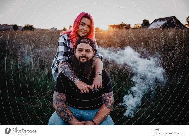 Paar mit Tattoos und pinken Haaren bei Sonnenuntergang Frau Mann Hipster trendy kuscheln innig pinke haare kornfeld Draussen paar liebe verliebt jugendlich nähe