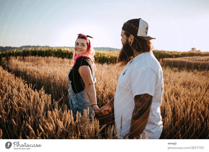 Paar mit Tattoos und pinken Haaren im Kornfeld Frau Mann Hipster trendy kuscheln innig pinke haare kornfeld Draussen paar liebe verliebt jugendlich nähe