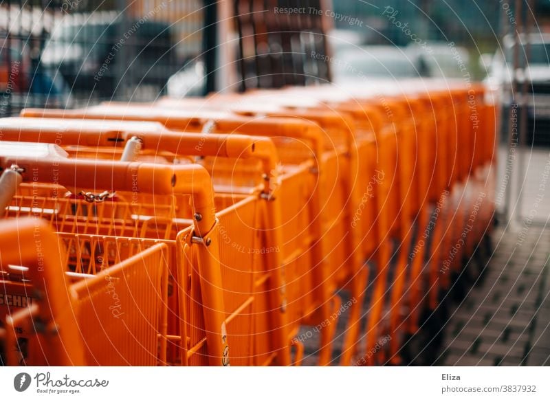 Eine Reihe orangener Einkaufswägen Baumarkt Einzelhandel einkaufen Supermarkt Einkaufswagen Handel