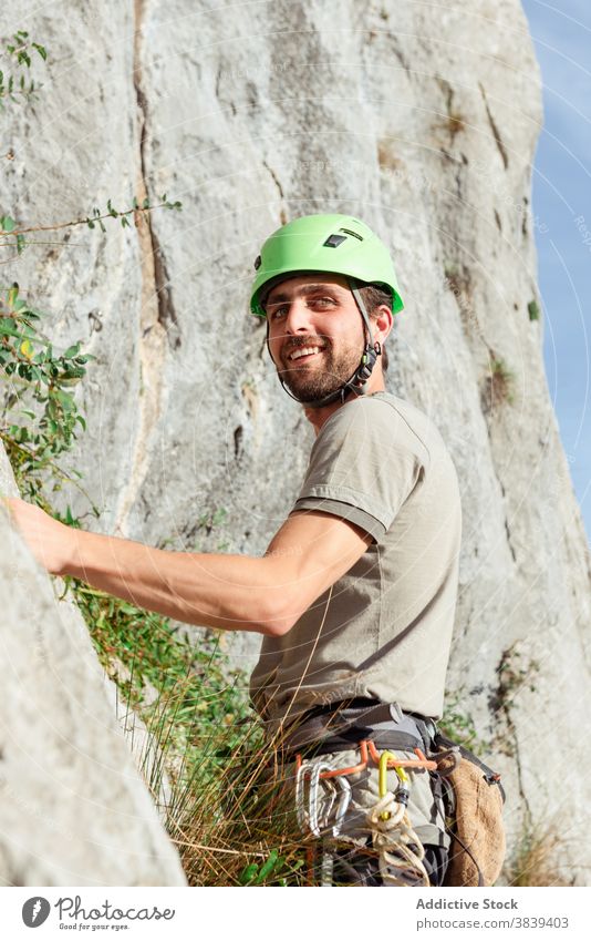 Mann in Sicherheitsgurt in der Nähe von Felsen Aufsteiger Kabelbaum vorbereiten Aufstieg extrem Abenteuer Gerät männlich sicher Karabiner Aktivität