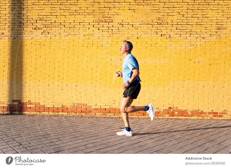 Senior Rentner läuft durch die Stadt auf gelbem Hintergrund 60 58 ruhen Rhythmus Gesundheitswesen Fitness Bluthochdruck Training kardial alt Hals Pflege passen