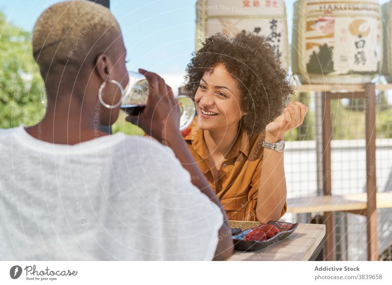 Frauen mit Weingläsern im Cafe Klirren Glas Freund Weinglas Café feiern festlich ethnisch schwarz Afroamerikaner trinken Glück heiter Terrasse Tisch Getränk