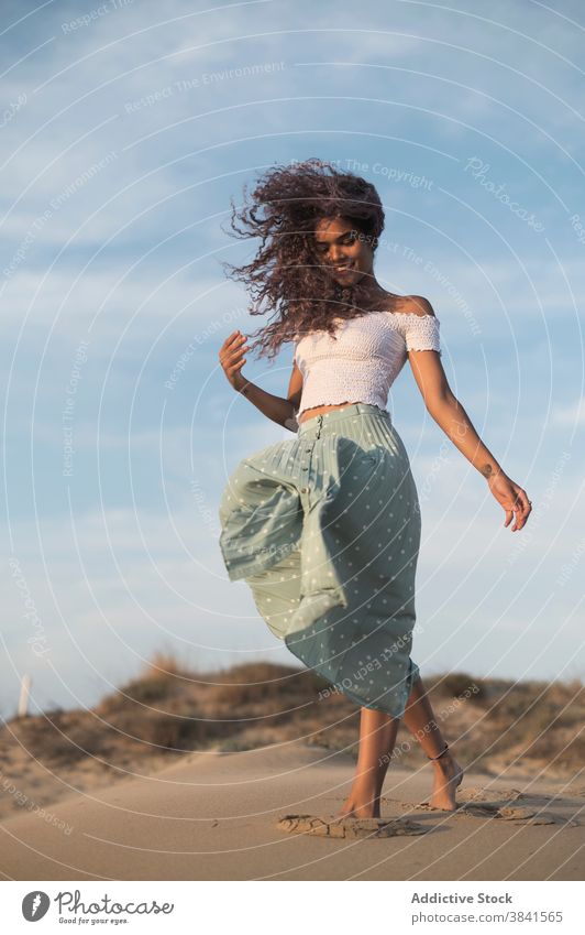 Serene Frau zu Fuß auf Sandstrand bei Sonnenuntergang sorgenfrei Sommer Spaziergang Strand Barfuß Anmut ruhig Outfit Hügel Natur charmant genießen Freiheit jung