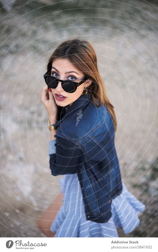 Stilvolle Frau in Jeansjacke in der Natur Jeansstoff Jacke sorgenfrei ruhig trendy cool Sonnenbrille lässig Mode jung ruhen genießen sich[Akk] entspannen