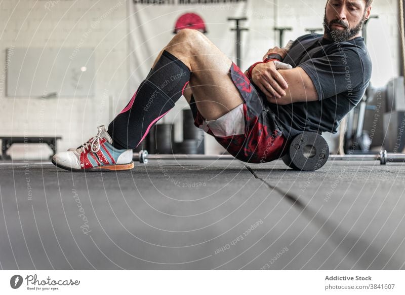 Männlicher Sportler beim Bauchmuskeltraining im Fitnessstudio Bauchmuskeln Unterleib Training knirschen Mann Gewichtheben Gewichtheber anstrengen muskulös