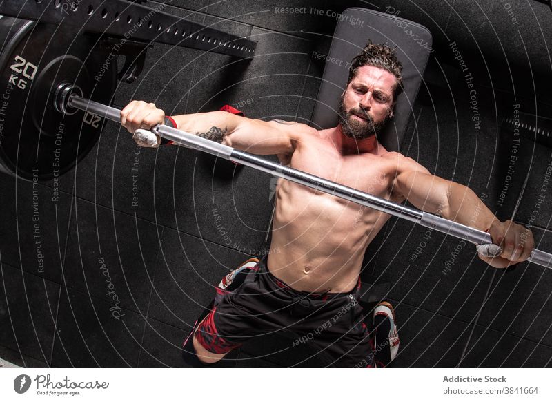 Ausdauernder Mann bei Gewichthebeübungen auf der Bankpresse Presse Übung Curl-Hantel Training Sportler Fitnessstudio anstrengen männlich Athlet Lügen stark