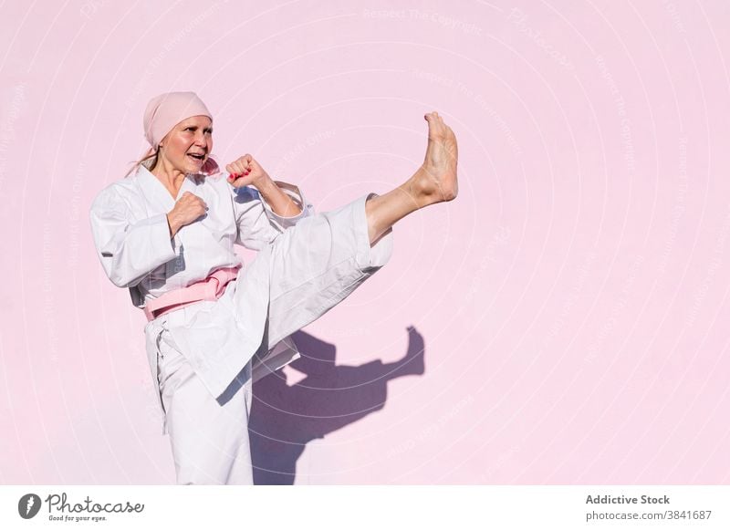 Karatefrau, die den Krebs besiegt hat Frau kämpferisch Kunst Sport Kampagne Erkenntnis Gesundheit Kämpfer rosa Foulard selbstbewusst Krankheit Vergebung stark