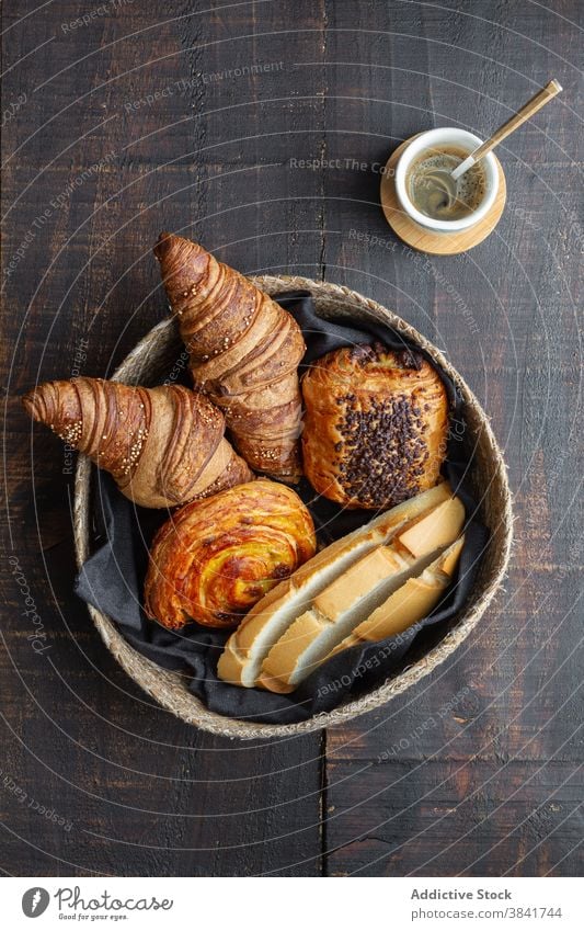 Verschiedene süße Backwaren im Korb Croissant Brötchen rollen Bäckerei selbstgemacht lecker hölzern Tisch heimwärts Lebensmittel geschmackvoll gebacken Brot