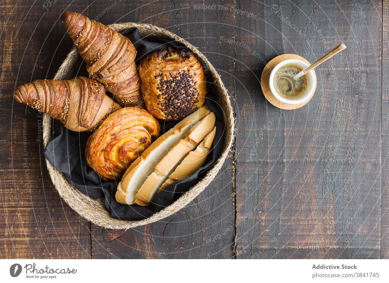 Verschiedene süße Backwaren im Korb Croissant Brötchen rollen Bäckerei selbstgemacht lecker hölzern Tisch heimwärts Lebensmittel geschmackvoll gebacken Brot