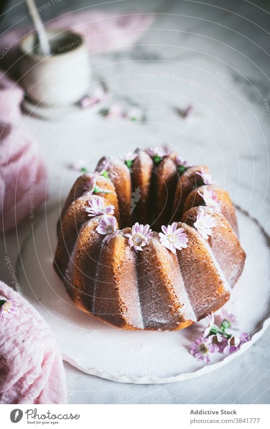 Appetitlicher Bundt-Kuchen mit Blumen auf dem Tisch Bundkuchen geschmackvoll Dekoration & Verzierung dienen Dessert süß lecker Küche Teller frisch Feinschmecker