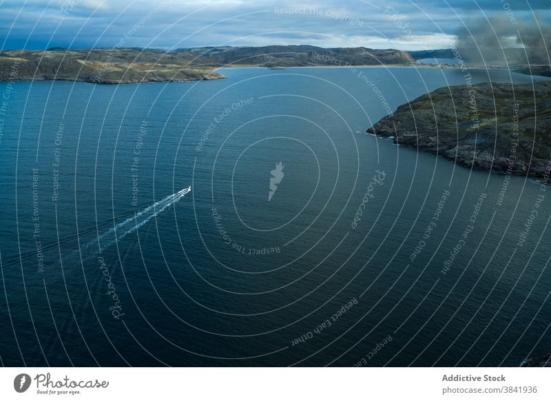 Motorboot schwimmt auf Geschwindigkeit im Meer Schwimmer MEER schnell Boot Meereslandschaft Berge u. Gebirge spektakulär blau Windstille malerisch Wasser Gefäße