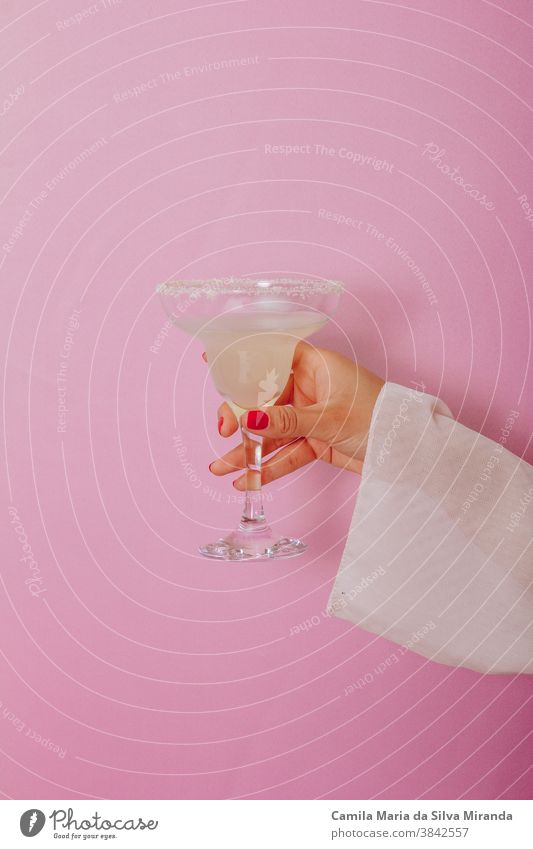 Weibliche Hand hält einen Cocktail - Rosa Hintergrund Lifestyle Cocktails appetitlich lecker Margarita klassisch Getränk alkoholisch tropisch Mojito Kalk