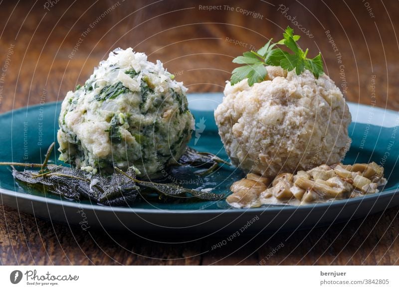 gemischte bayerische Knödel auf Holz Essen Küche hausgemacht österreichisch Spinatknödel Pilzsauce Pilzsoße traditionell europäisch gekocht semmelknödel