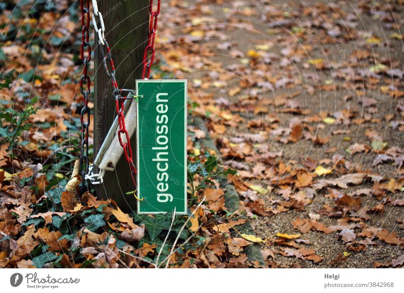 offen - Schild "geschlossen" hängt samt Absperrkette an einem Pfahl neben dem Weg, der mit Herbstlaub bedeckt ist Absperrung Blätter Laub Herbstfärbung