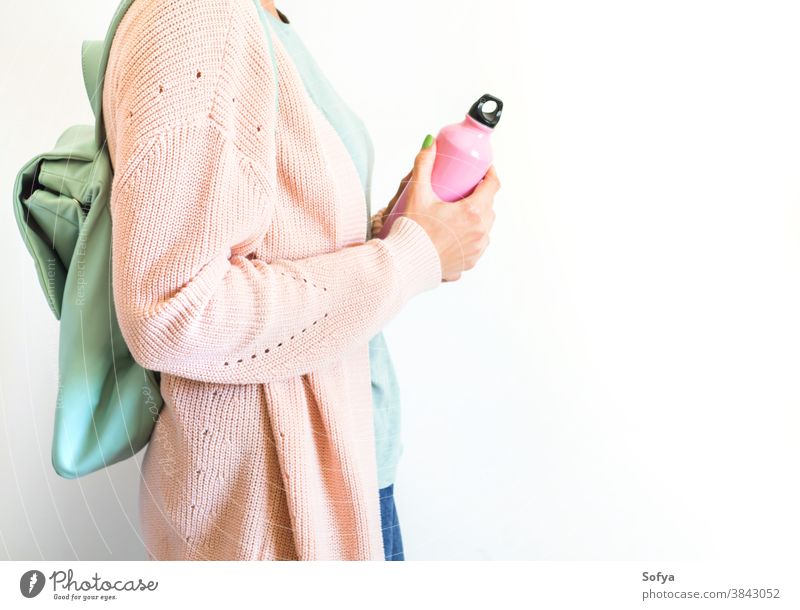 Frau in Pastell mit Rucksack und wiederverwendbarer Flasche rosa Wasser Lifestyle keine Verschwendung trinken Mode Öko Nachfüllen frei Konzept Hipster Tasche