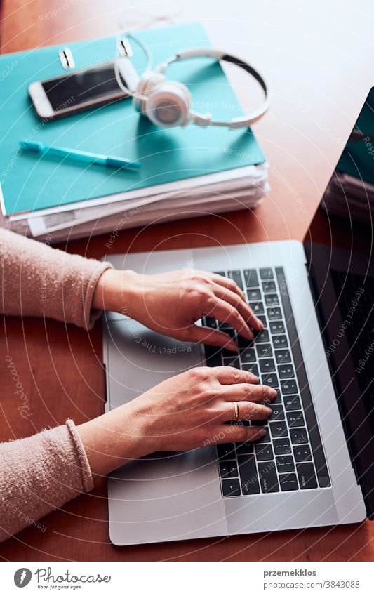 Frau, die während eines Videochat-Telefongesprächs mit einem Laptop von zu Hause aus arbeitet und dabei ihre Arbeit aus der Ferne erledigt Ordner Anruf