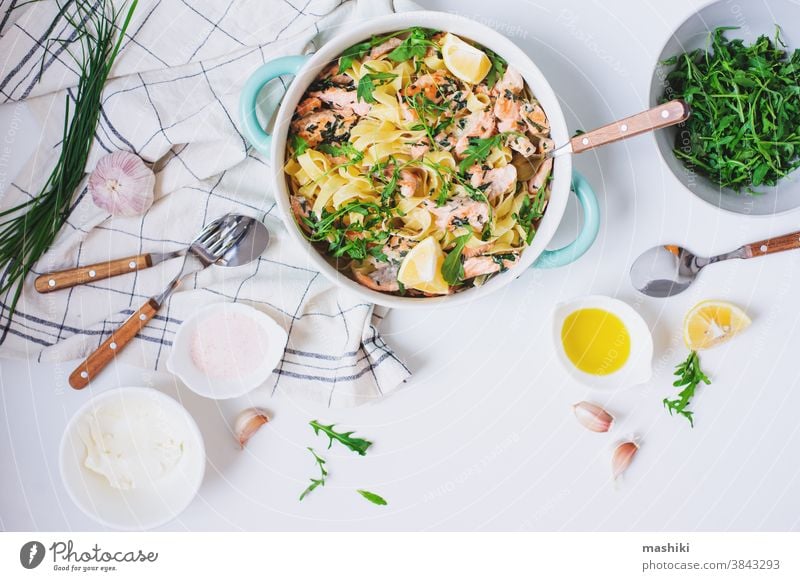 Italienische Küche - cremige Lachsnudeln mit Rucola, Spinat und Käse, serviert mit Zitrone Lebensmittel Spätzle Abendessen Fisch Mittagessen Saucen Gesundheit