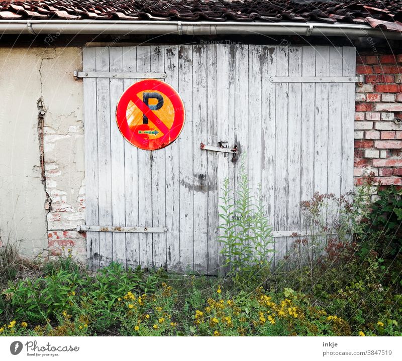 Parkverbotsschild am Holztor im Hinterhof farbfoto Außenaufnahme Menschenleer Schild Verbotsschild Garage verwildert rot Unkraut Schilder & Markierungen Mauer